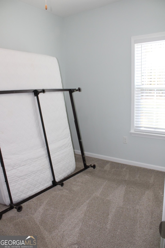 exercise room with carpet floors and baseboards