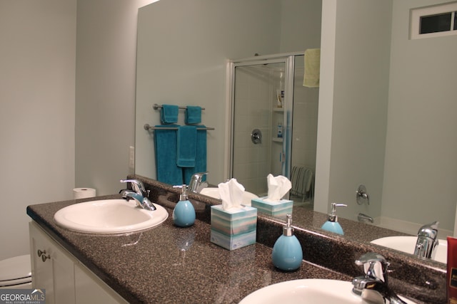 bathroom with double vanity, a tile shower, and a sink