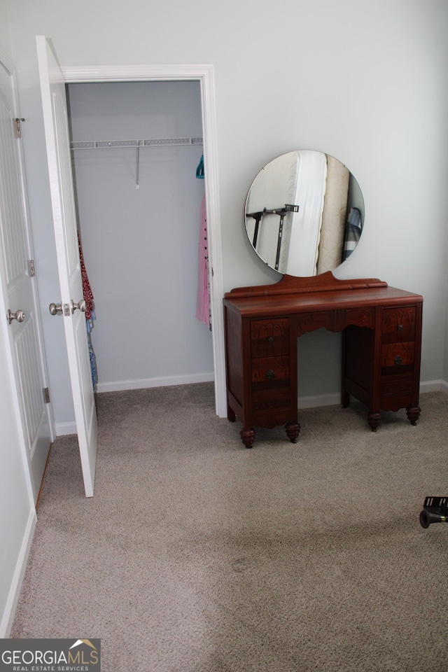 bedroom featuring a closet, light colored carpet, and baseboards