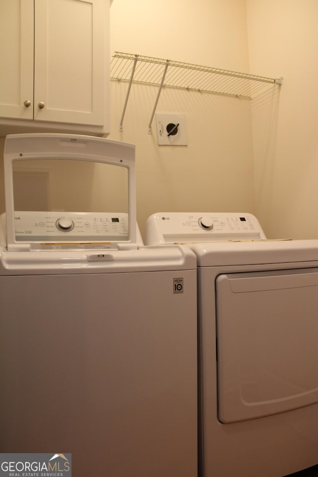 washroom with washing machine and dryer and cabinet space