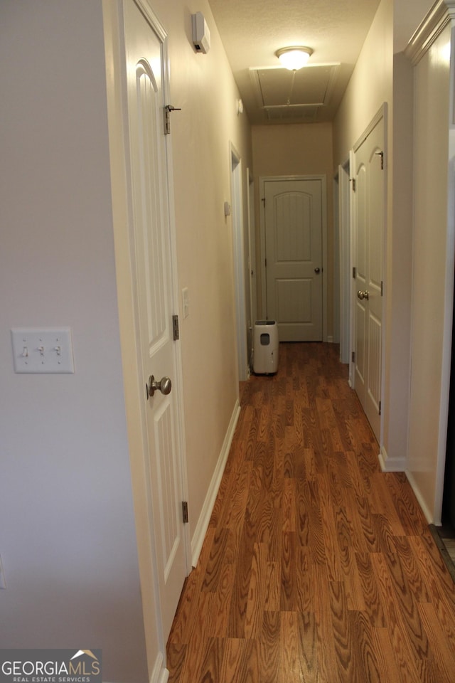 hall featuring wood finished floors and baseboards