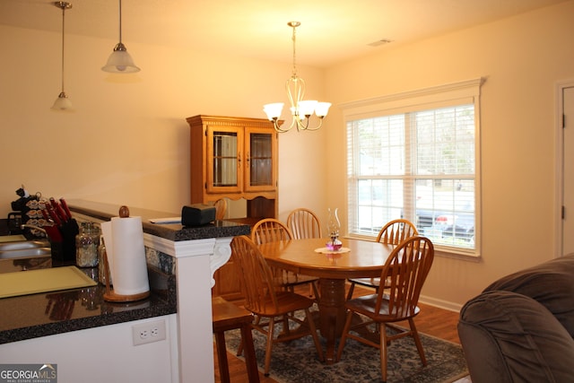 dining area featuring a chandelier, dark wood finished floors, visible vents, and baseboards