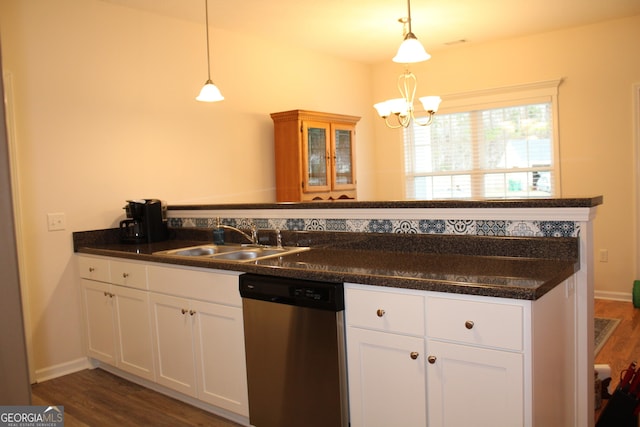 kitchen with dark countertops, hanging light fixtures, white cabinetry, a sink, and dishwasher