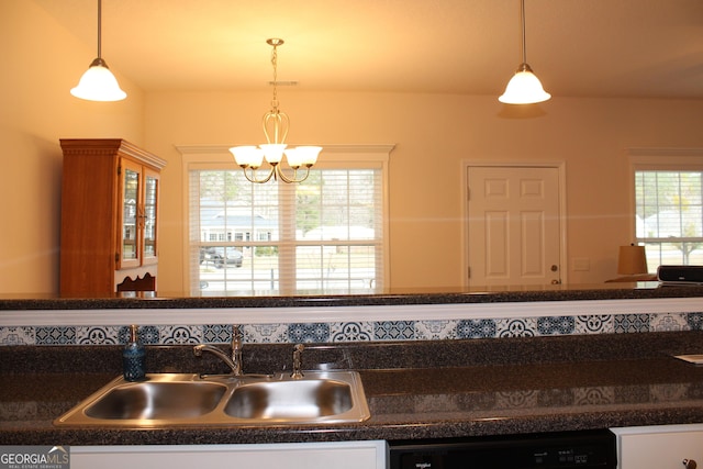 kitchen featuring dark countertops, pendant lighting, a sink, and dishwasher