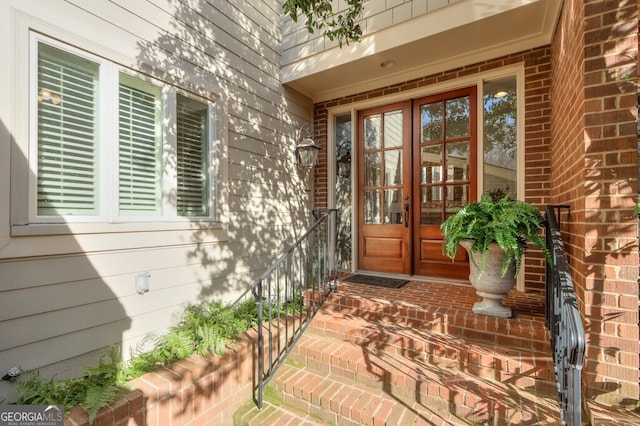 doorway to property featuring french doors and brick siding