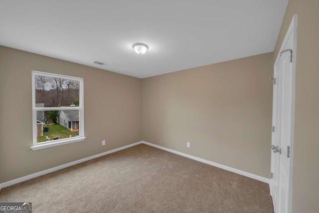 spare room featuring carpet flooring, visible vents, and baseboards