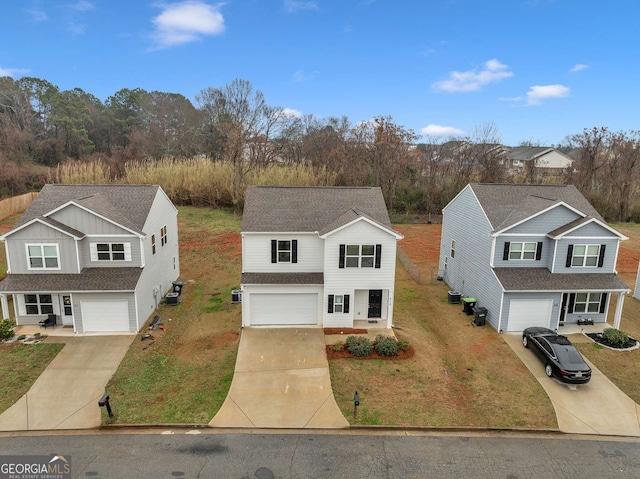 view of front of property featuring a front lawn, concrete driveway, a shingled roof, and an attached garage