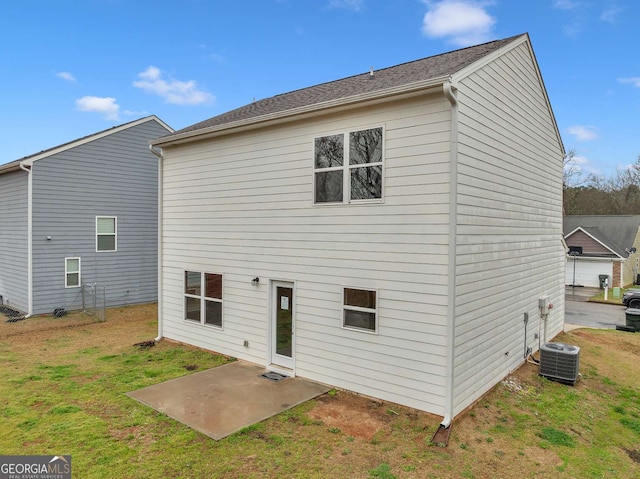 rear view of property featuring central AC unit, a lawn, and a patio