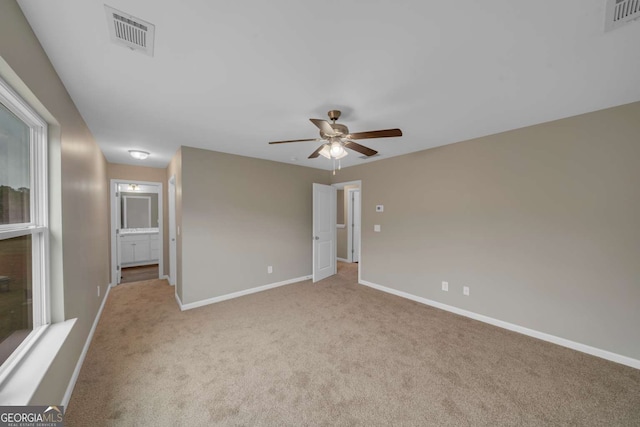 spare room featuring light carpet, baseboards, visible vents, and ceiling fan