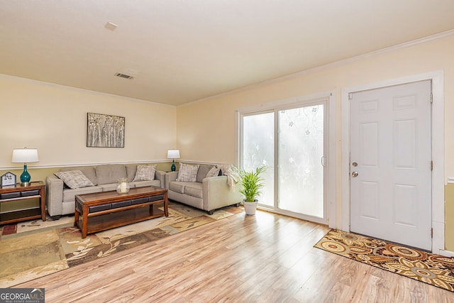 living area featuring ornamental molding, wood finished floors, and visible vents