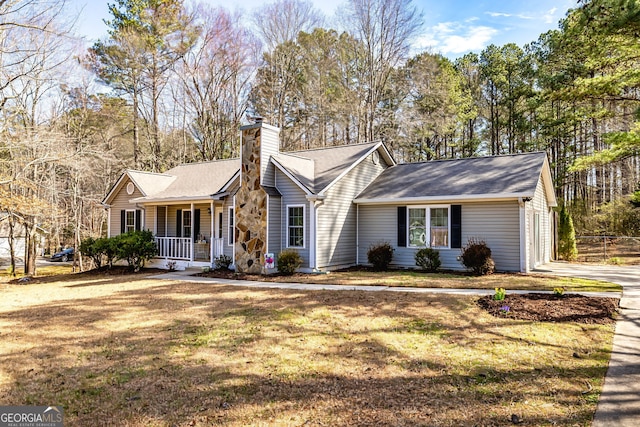 ranch-style home with a front yard, covered porch, and a chimney