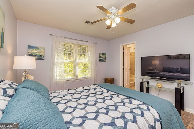 bedroom featuring ceiling fan, connected bathroom, visible vents, and wood finished floors