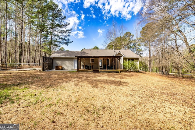 back of house featuring fence and a wooden deck