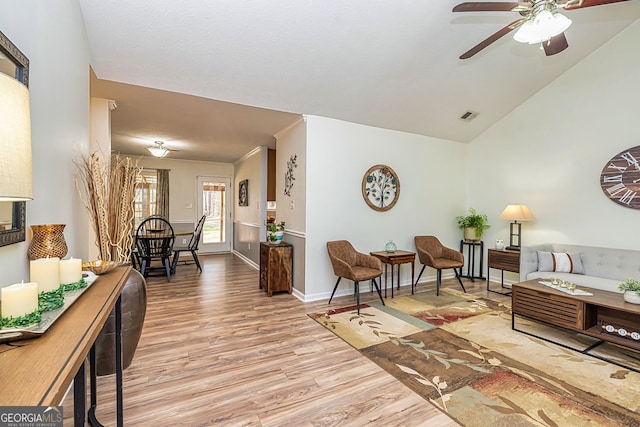 living room with visible vents, a ceiling fan, vaulted ceiling, wood finished floors, and baseboards