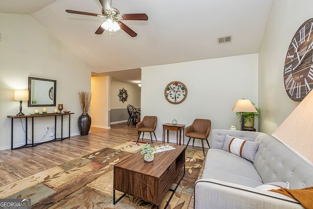 living area featuring lofted ceiling, wood finished floors, visible vents, and a ceiling fan