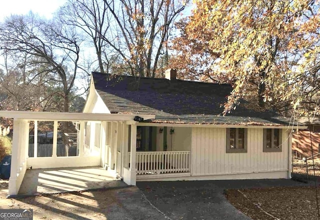 view of front of house featuring a porch and a chimney