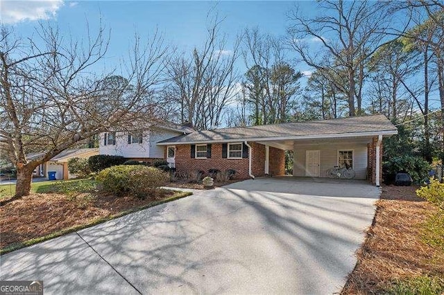 tri-level home featuring driveway and brick siding