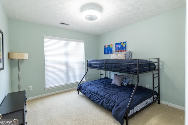 bedroom with a textured ceiling, baseboards, and carpet flooring