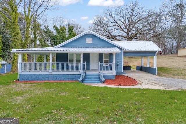 farmhouse inspired home featuring covered porch, driveway, metal roof, and a front yard