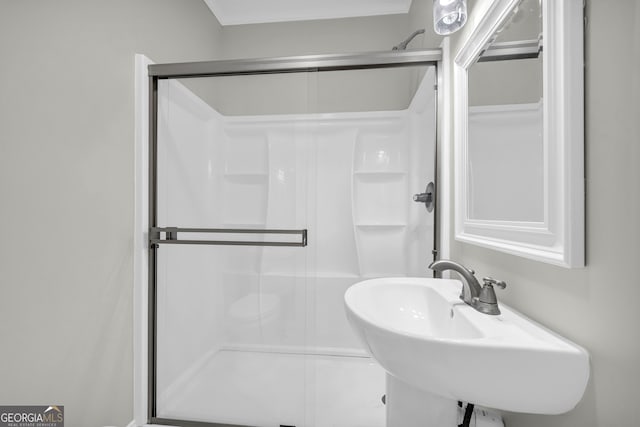 bathroom featuring a stall shower and a sink