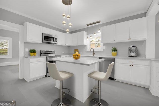 kitchen featuring light countertops, appliances with stainless steel finishes, a breakfast bar, and white cabinets