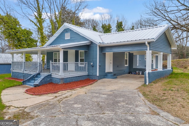 view of front of home featuring metal roof, a porch, an attached carport, driveway, and crawl space