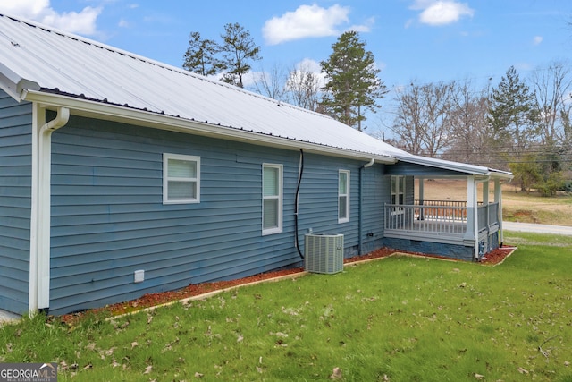 view of home's exterior with central air condition unit, crawl space, metal roof, and a yard