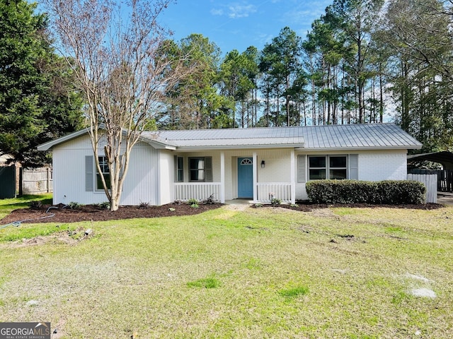 ranch-style house with brick siding, metal roof, a front lawn, and fence