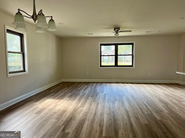 unfurnished room featuring a healthy amount of sunlight, baseboards, and wood finished floors