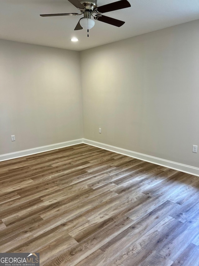 unfurnished room featuring a ceiling fan, baseboards, and wood finished floors