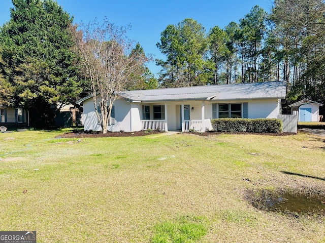 ranch-style house with covered porch, a shed, an outbuilding, and a front yard