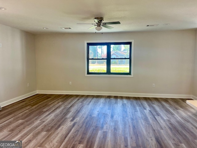 unfurnished room with baseboards, visible vents, and wood finished floors