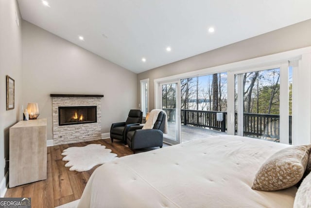 bedroom with access to outside, vaulted ceiling, wood finished floors, and recessed lighting