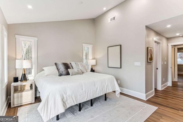 bedroom with recessed lighting, wood finished floors, visible vents, baseboards, and vaulted ceiling