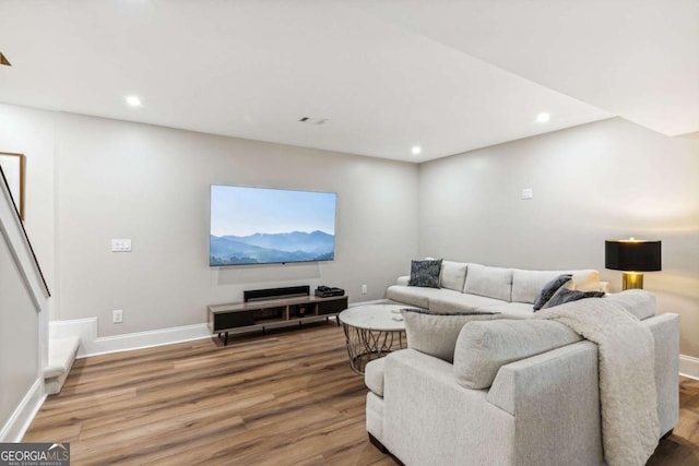 living area featuring baseboards, wood finished floors, and recessed lighting