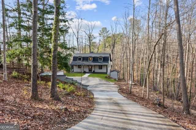 view of front of home featuring concrete driveway, roof with shingles, and an outdoor structure