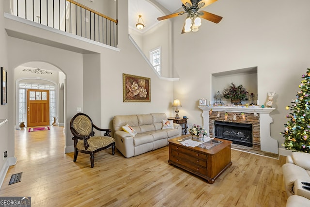 4010 Tamarack Dr NW, Kennesaw, GA 30152 - living area featuring visible vents, arched walkways, a stone fireplace, light wood finished floors, and ceiling fan