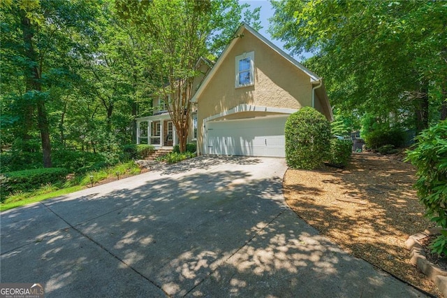 view of front of home with stucco siding, driveway, and a garage