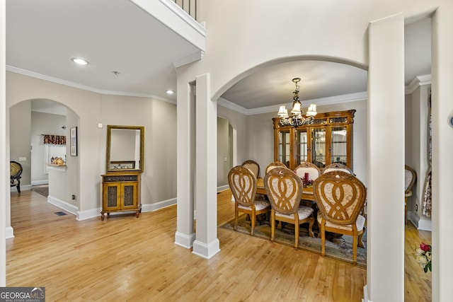 4010 Tamarack Dr NW, Kennesaw, GA 30152 - dining space featuring arched walkways, light wood-style flooring, an inviting chandelier, and ornamental molding