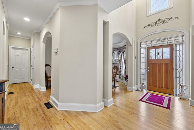 4010 Tamarack Dr NW, Kennesaw, GA 30152 - foyer with arched walkways, light wood finished floors, crown molding, and baseboards