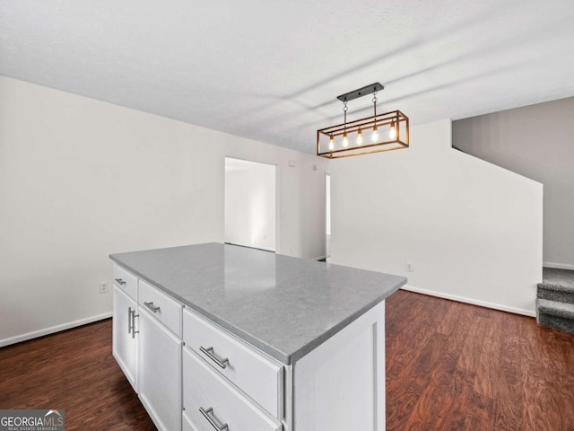 kitchen with dark wood-style floors, a center island, pendant lighting, and white cabinets