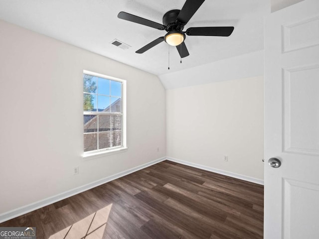 unfurnished bedroom featuring dark wood-type flooring, lofted ceiling, visible vents, and baseboards