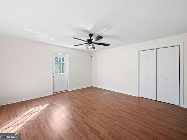 unfurnished bedroom featuring ceiling fan, baseboards, and wood finished floors