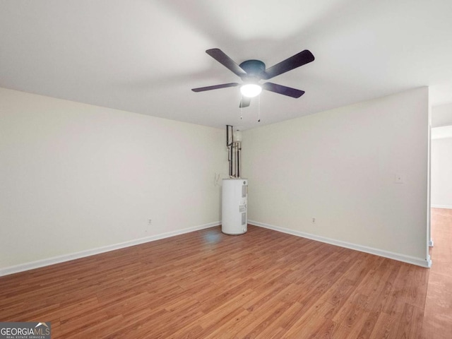 unfurnished living room featuring light wood-style floors, water heater, baseboards, and a ceiling fan