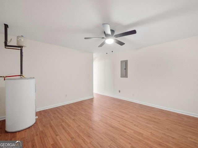 empty room featuring light wood-style flooring, electric panel, baseboards, and a ceiling fan