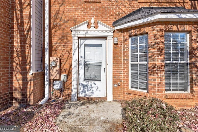 view of exterior entry with brick siding