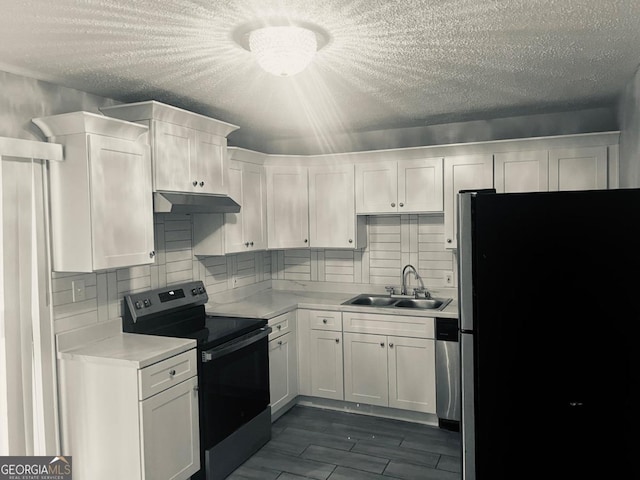 kitchen with light countertops, appliances with stainless steel finishes, a sink, and white cabinetry