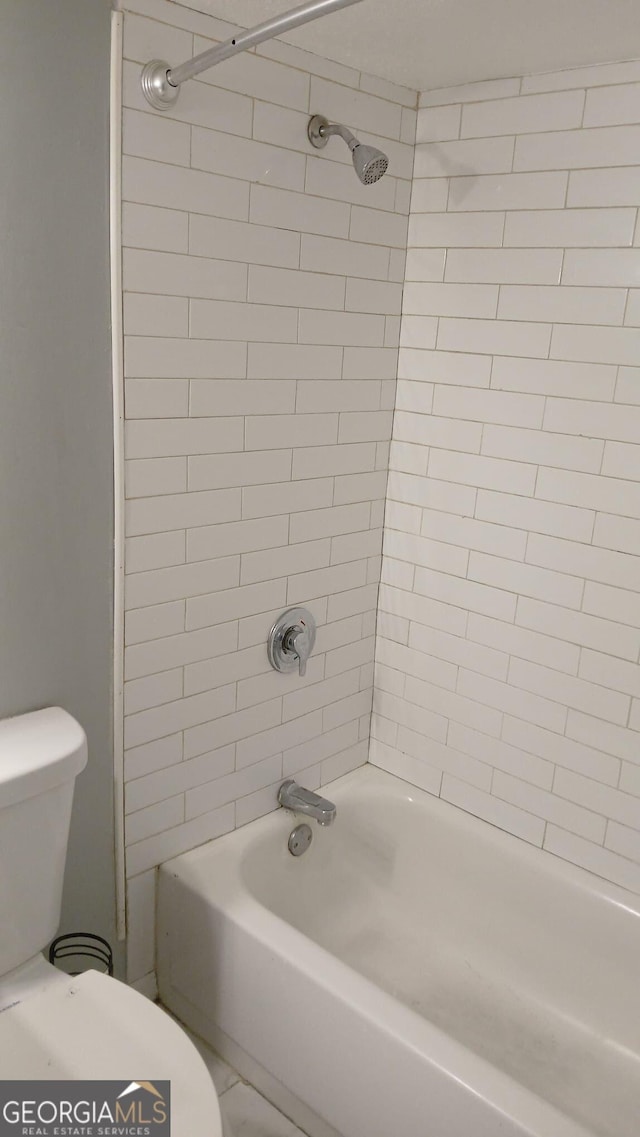 bathroom with toilet and bathing tub / shower combination