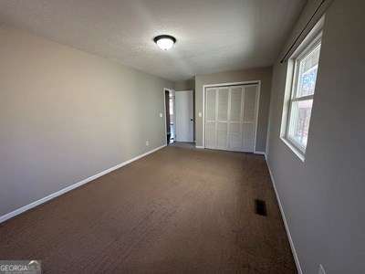 unfurnished bedroom featuring a closet, carpet, visible vents, and baseboards