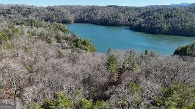 aerial view with a water view and a wooded view